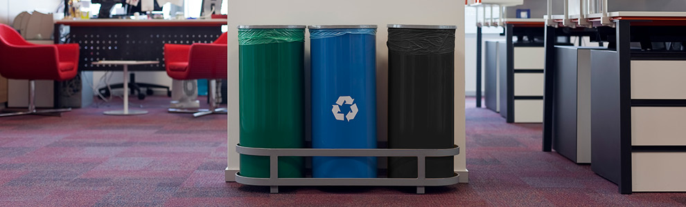 Office space with a green bin for organics collection, blue bin for recycling, and black bin for garbage