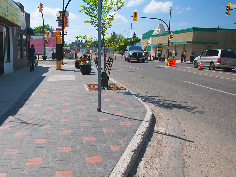 20th Street west street after construction. Image highlights a rejuvenated public realm with new unit pavers, street furniture, and trees.