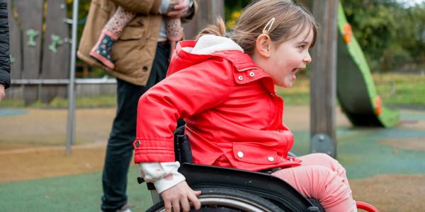 Little girl in wheelchair on an accessible playground